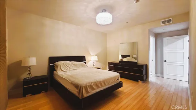a bedroom with a bed and wooden floor