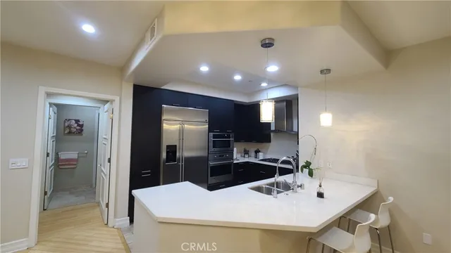 a kitchen with kitchen island a sink stainless steel appliances and refrigerator