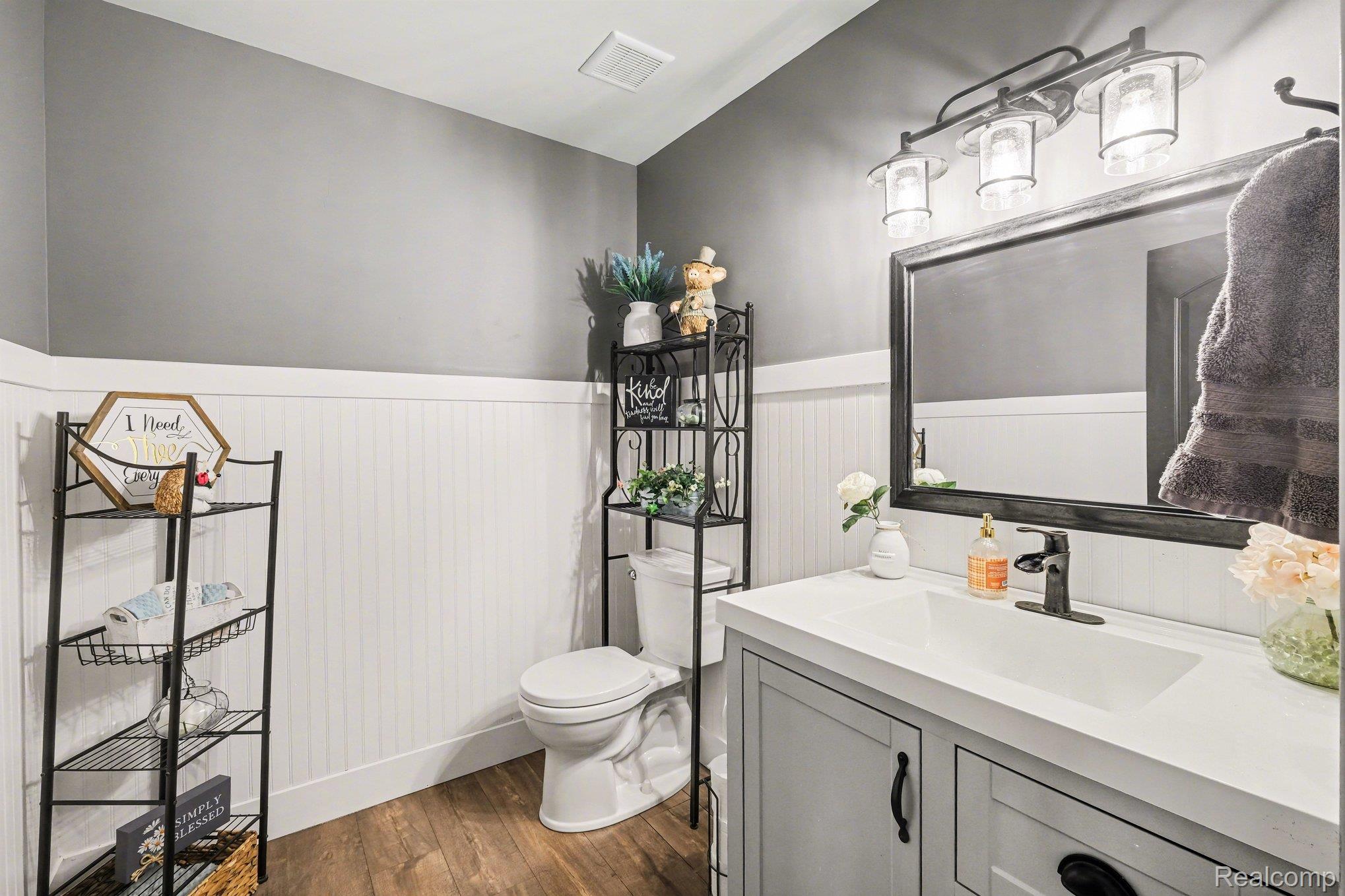 9084 Copper Ridge Drive Davison, MI 48423 - Photo 29 of 42 Bathroom featuring vanity, dark wood finished floors, and wainscoting