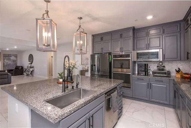 a kitchen with stainless steel appliances granite countertop a sink refrigerator and cabinets