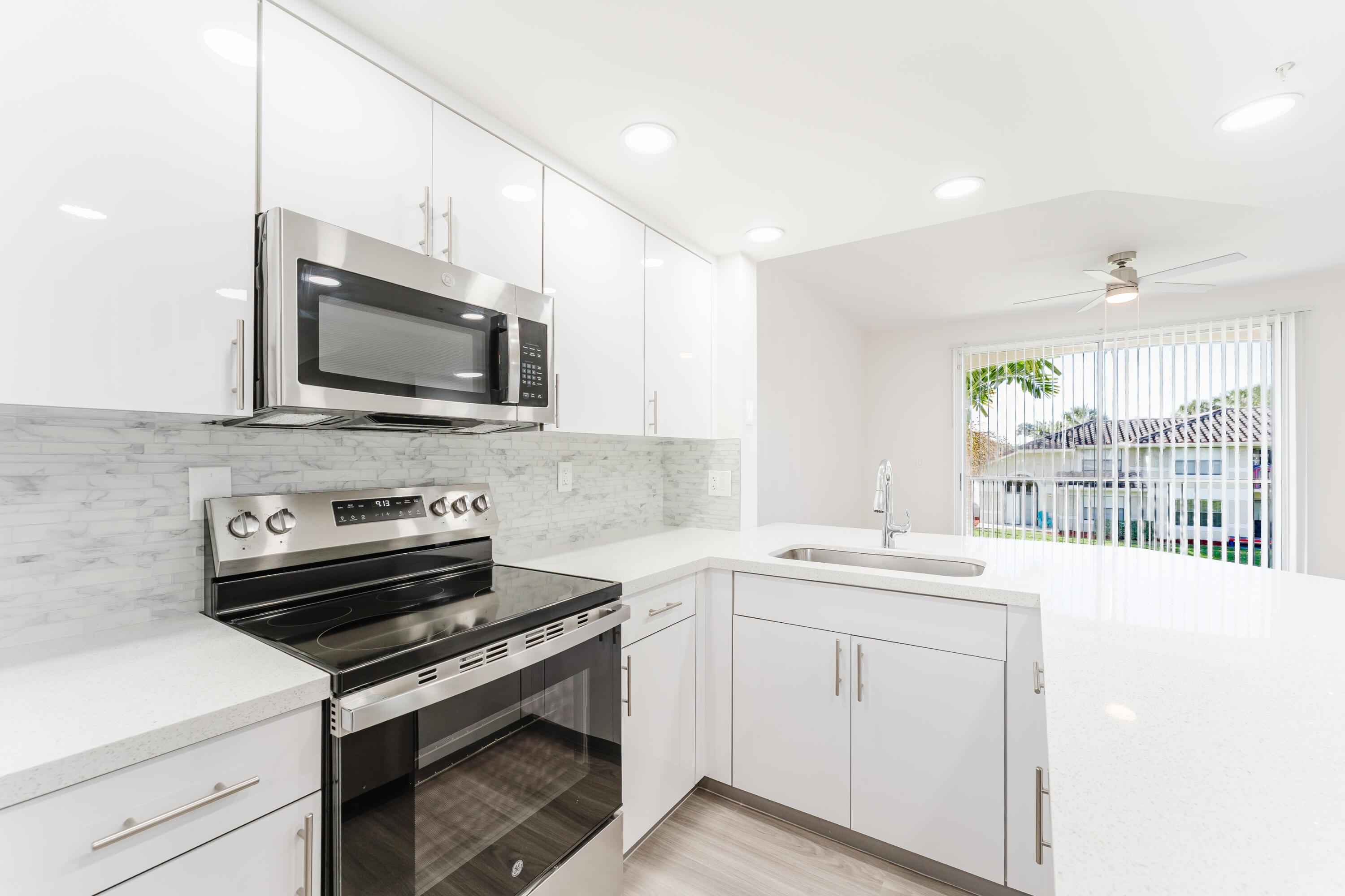 20889 St Andrews Boulevard Boca Raton, FL 33433 - Photo 12 of 46 a kitchen with a stove a sink and a microwave