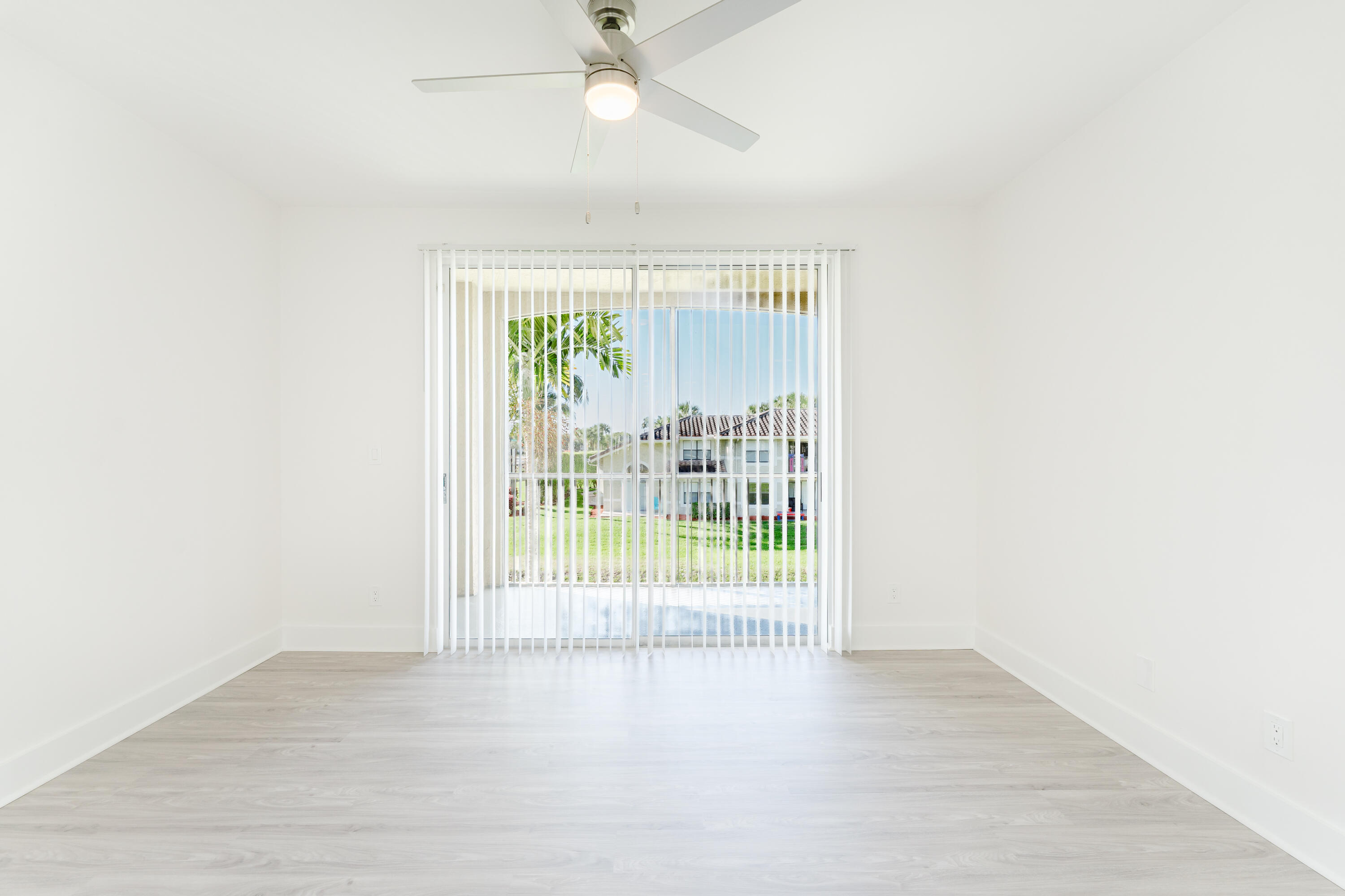 20889 St Andrews Boulevard Boca Raton, FL 33433 - Photo 13 of 46 an empty room with wooden floor and windows