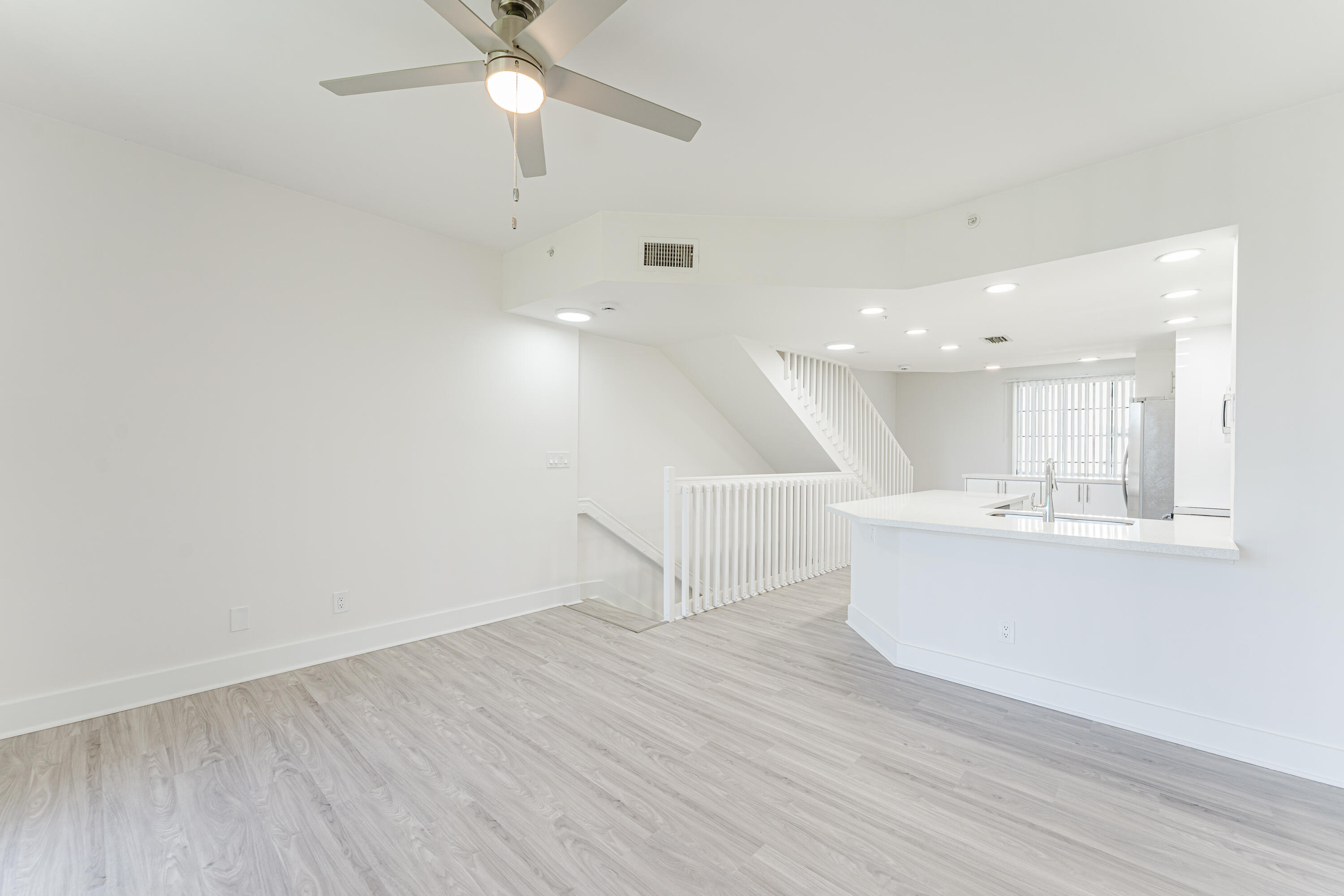20889 St Andrews Boulevard Boca Raton, FL 33433 - Photo 15 of 46 a view of an empty room with wooden floor and a ceiling fan