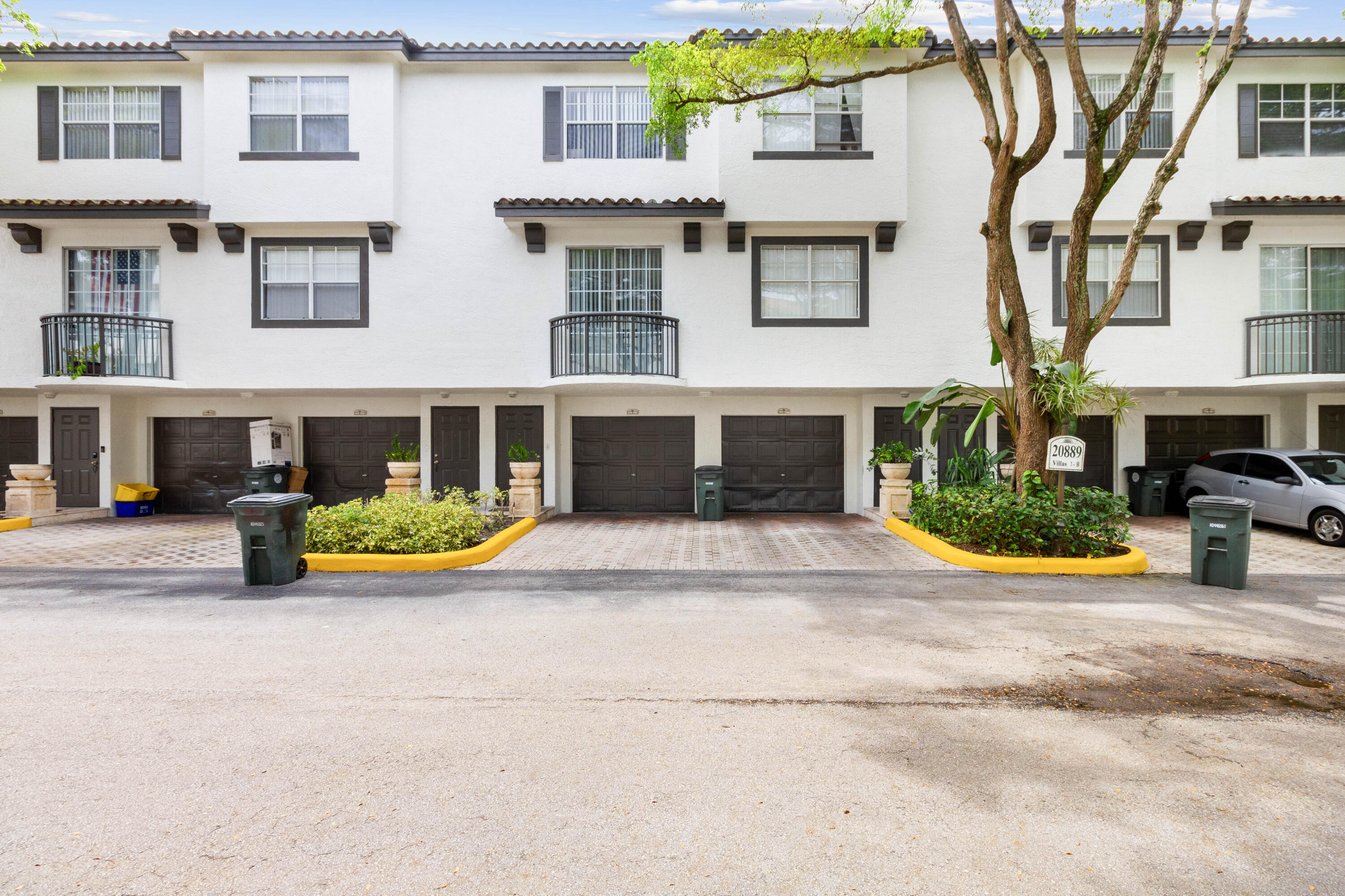 20889 St Andrews Boulevard Boca Raton, FL 33433 - Photo 2 of 46 front view of a brick house with a yard and large windows
