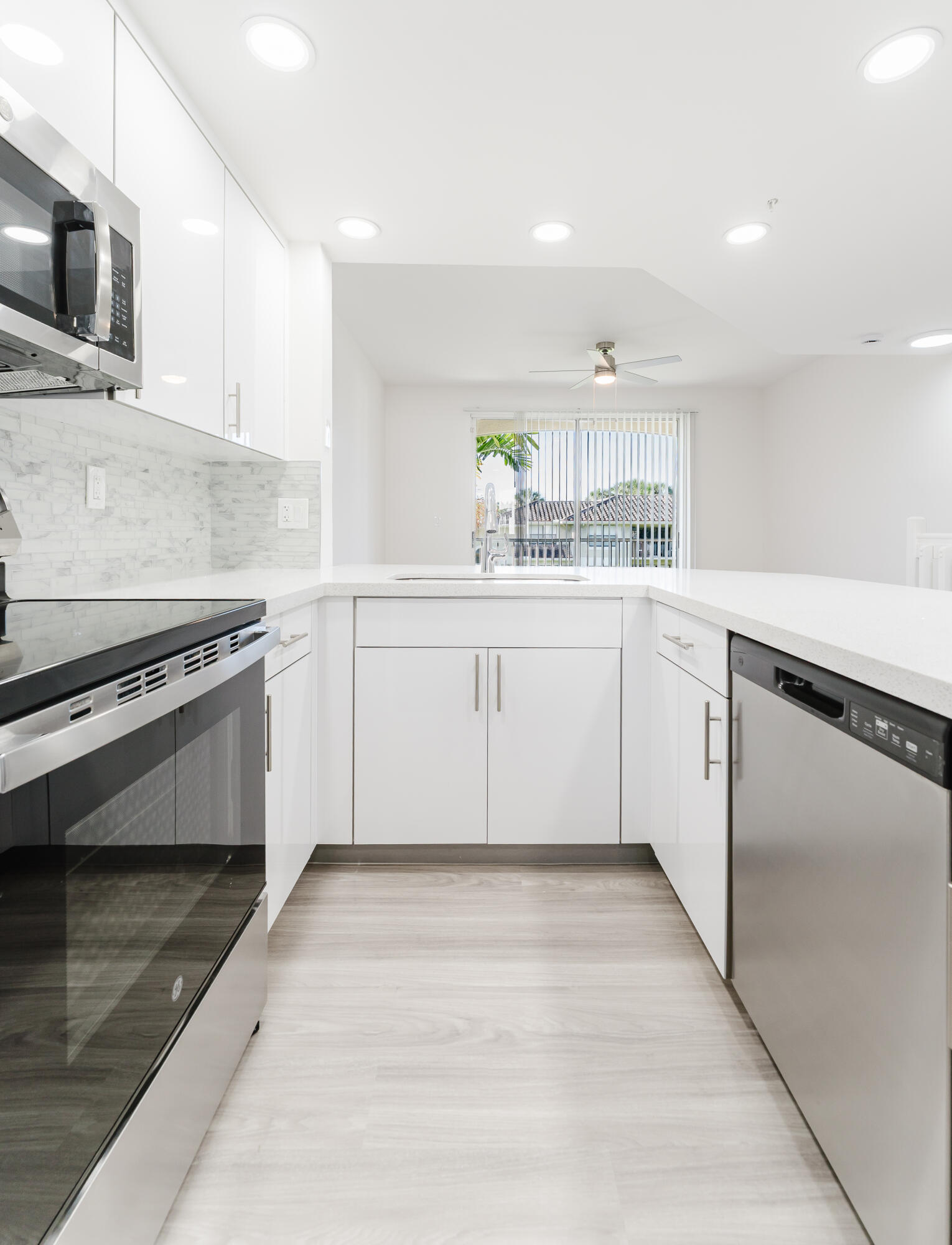 20889 St Andrews Boulevard Boca Raton, FL 33433 - Photo 35 of 46 a kitchen with granite countertop white cabinets and white appliances