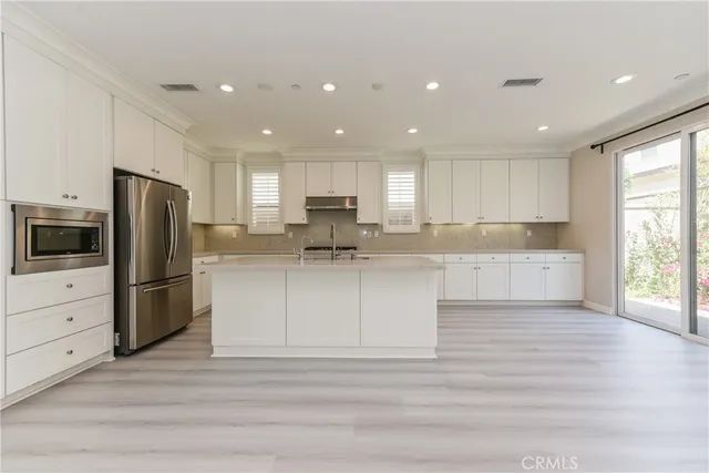 a kitchen with a refrigerator and a stove top oven