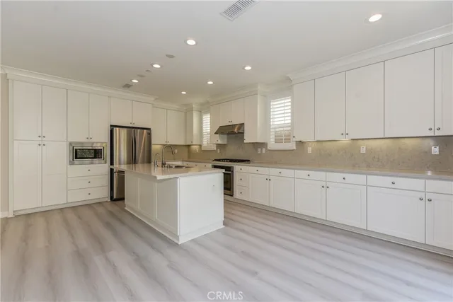 a kitchen with granite countertop white cabinets and stainless steel appliances