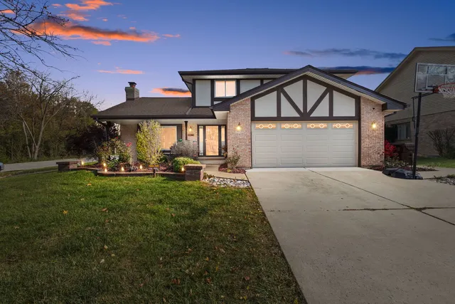 a front view of a house with a yard and a garage