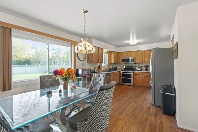 a view of a dining room and livingroom with furniture large windows a chandelier