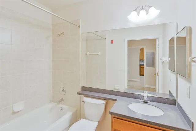 a bathroom with a granite countertop sink a mirror and a bathtub