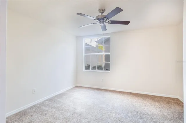 an empty room with a window and a fan