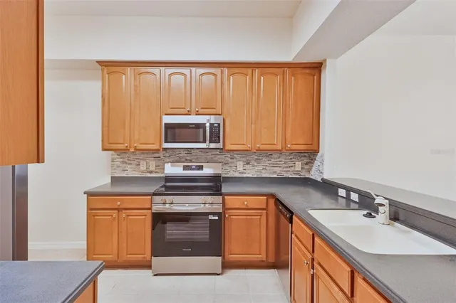 a kitchen with stainless steel appliances granite countertop a sink stove and microwave