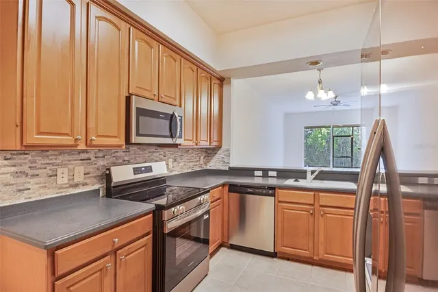 a kitchen with stainless steel appliances granite countertop a sink stove and cabinets