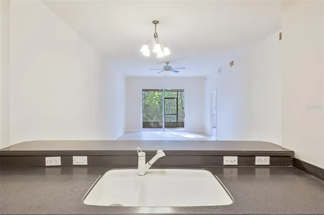 an empty room with a window and a ceiling fan