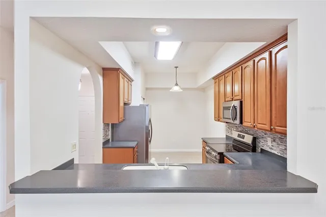 a kitchen with kitchen island a counter top space a sink and a refrigerator