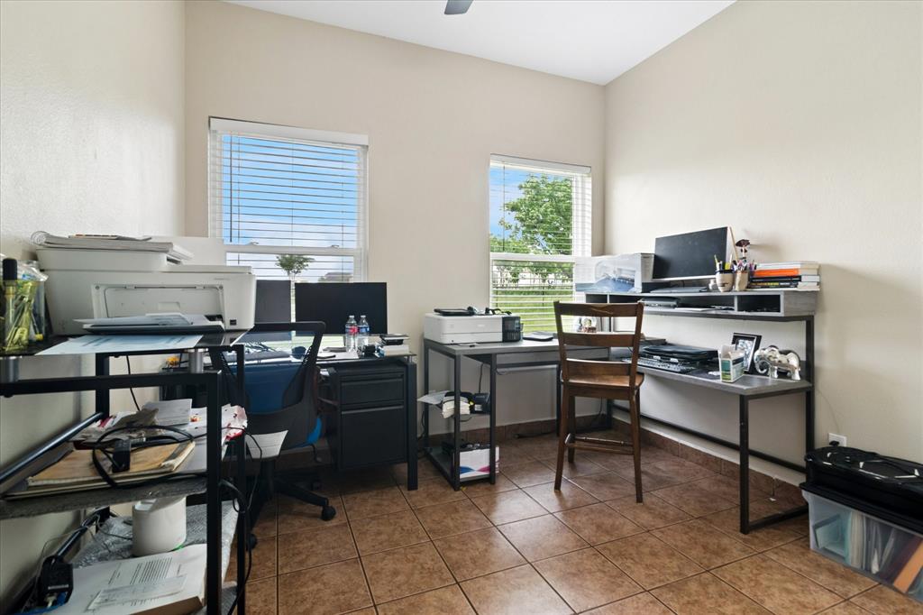 6005 Hawkeye Road Krum, TX 76249 - Photo 12 of 27 Neutral-toned room featuring a vaulted ceiling and two windows with horizontal blinds