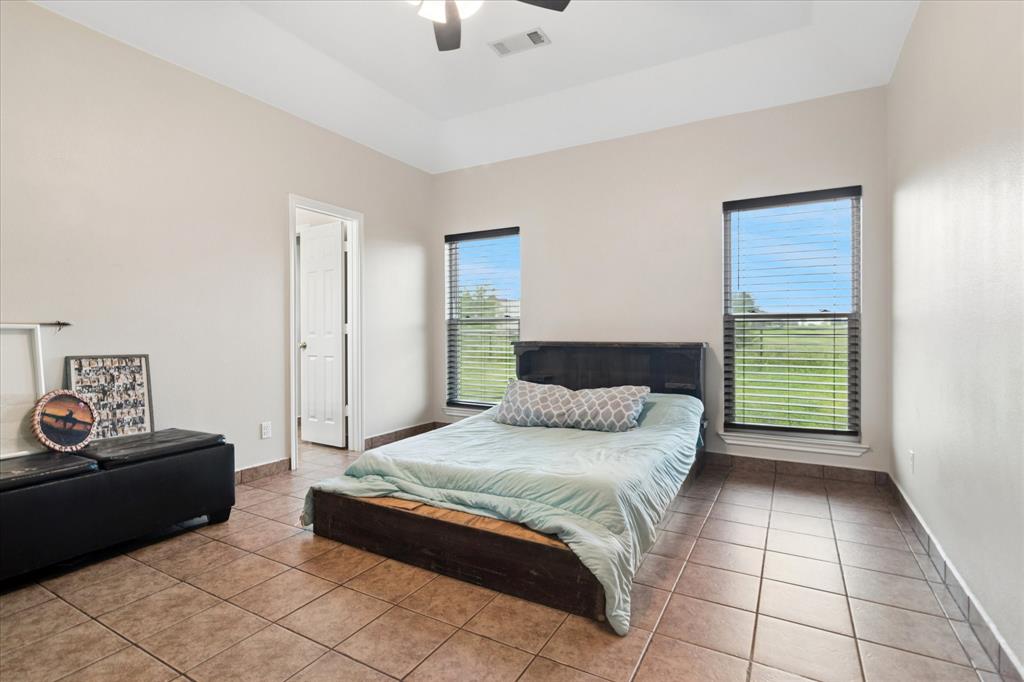 6005 Hawkeye Road Krum, TX 76249 - Photo 13 of 27 Spacious room with tray ceiling, tile flooring, and multiple windows with blinds