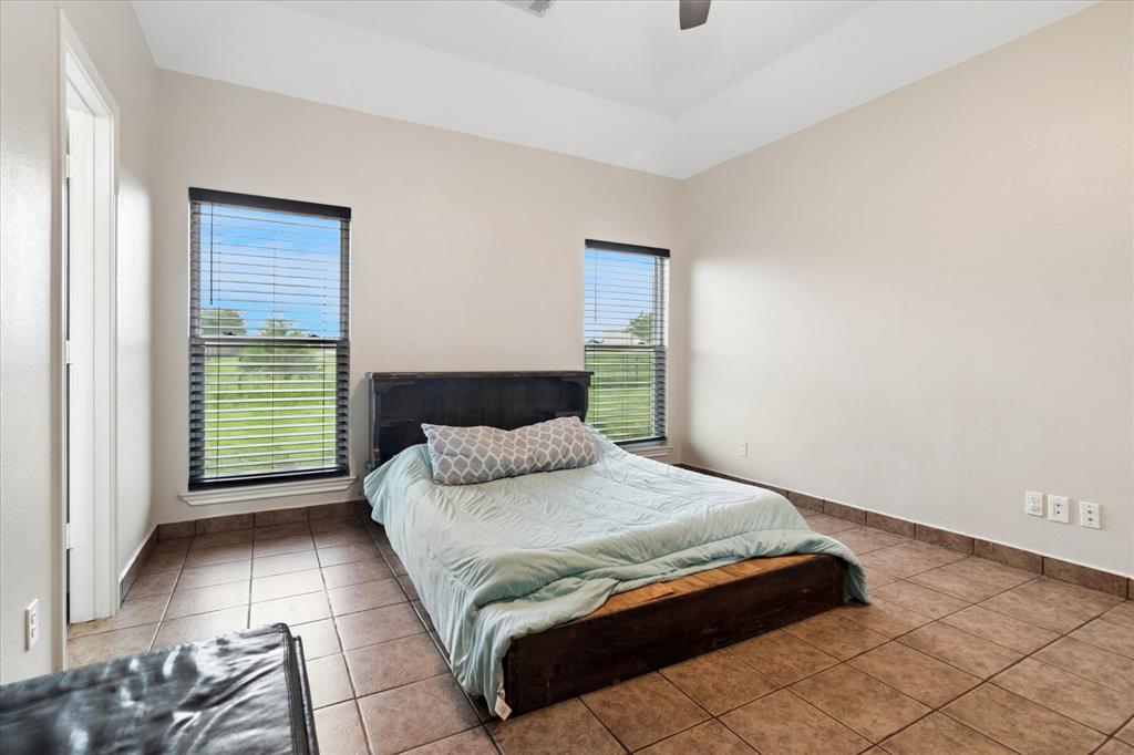 6005 Hawkeye Road Krum, TX 76249 - Photo 14 of 27 Spacious room featuring neutral painted walls, ceramic tile flooring, a tray ceiling, and dual windows with blinds