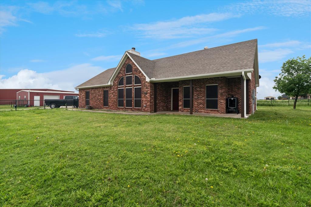 6005 Hawkeye Road Krum, TX 76249 - Photo 6 of 27 Brick-clad exterior with a prominent arched window feature and gabled roofline