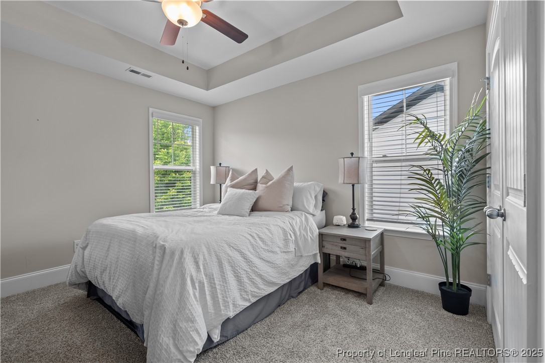 479 Kerr Lake Road Aberdeen, NC 28315 - Photo 25 of 43 a large bed sitting in a bedroom next to a window and a chandelier