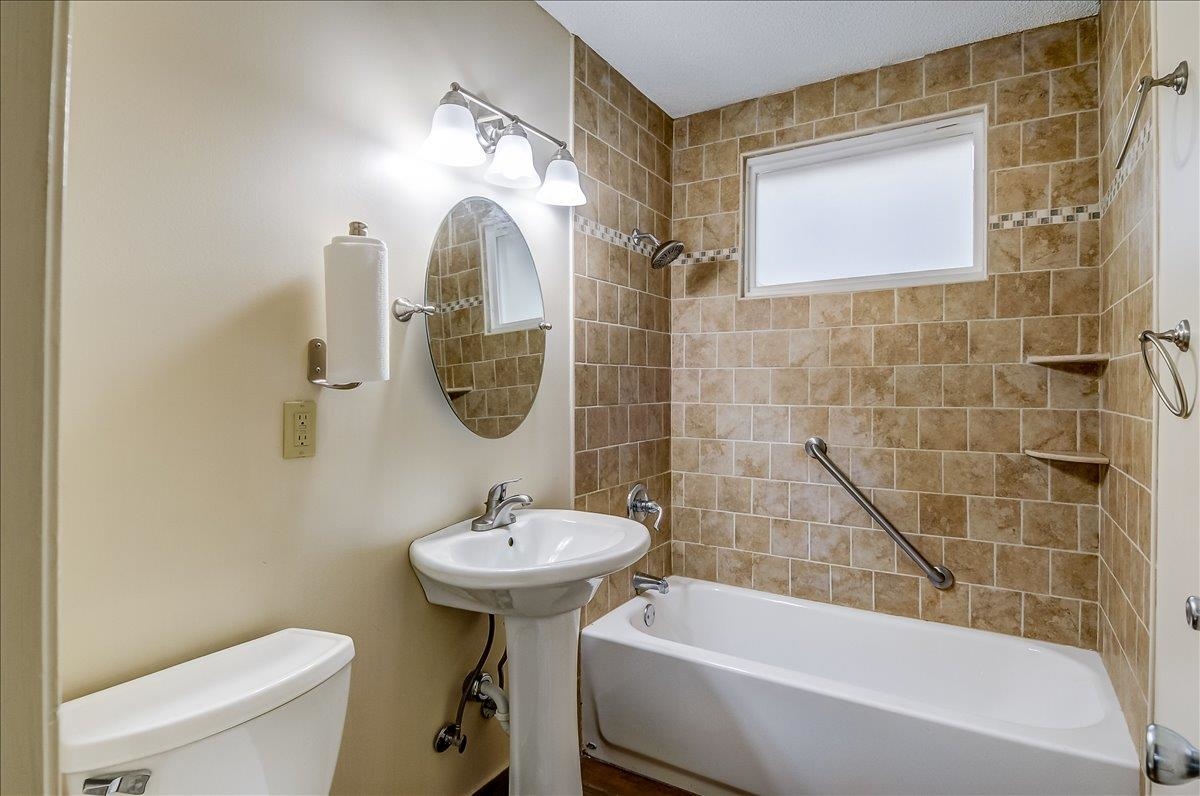 1411 Roberts Road Memphis, TN 38106 - Photo 15 of 24 Bathroom featuring a pedestal sink, oval mirror, and a three-light vanity fixture