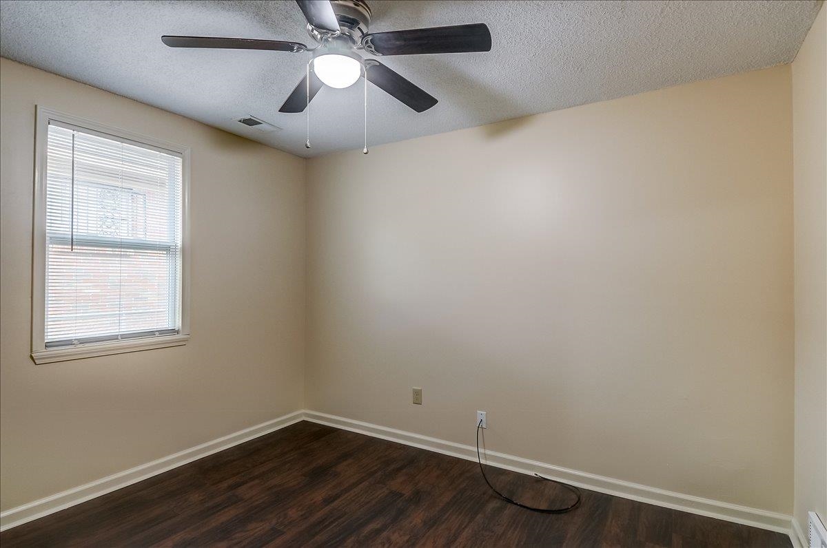 1411 Roberts Road Memphis, TN 38106 - Photo 20 of 24 Room featuring dark wood-finish flooring, light neutral-toned walls, and white baseboards