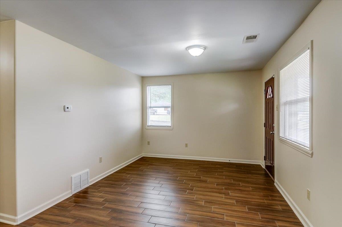 1411 Roberts Road Memphis, TN 38106 - Photo 7 of 24 Expansive interior room featuring wood-finish flooring, light-toned wall paint, white baseboards, and a flush-mount ceiling light fixture