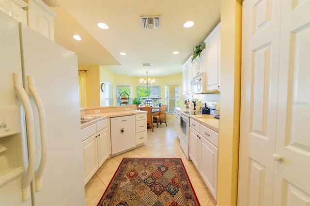a large white kitchen with lots of counter space and wooden floor
