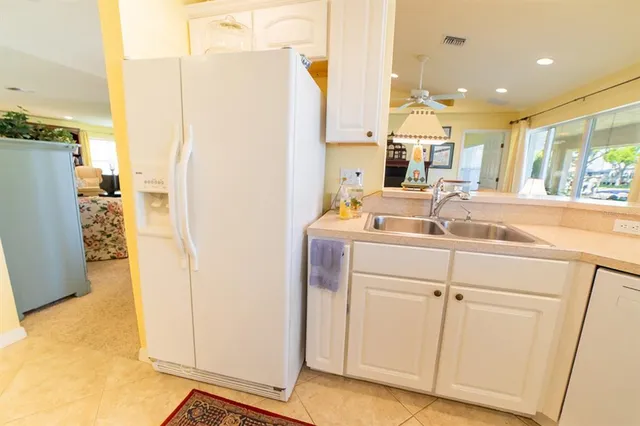 a room with kitchen island a sink a counter top space and a view of living room
