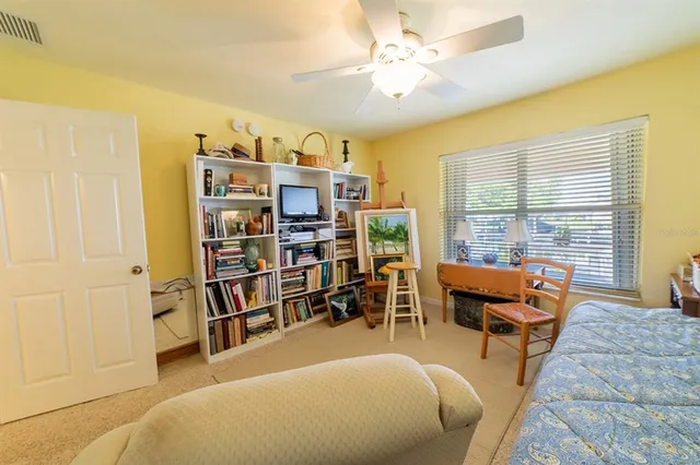 a living room with furniture a bookshelf and a large window