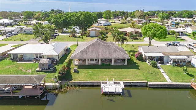 an aerial view of a house with a garden and lake view