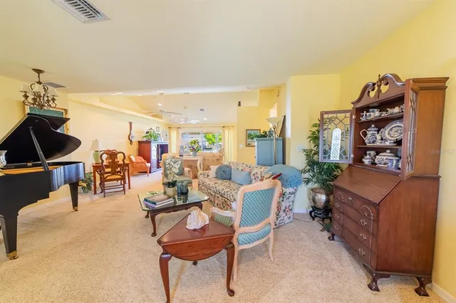 a living room with furniture a rug and a piano