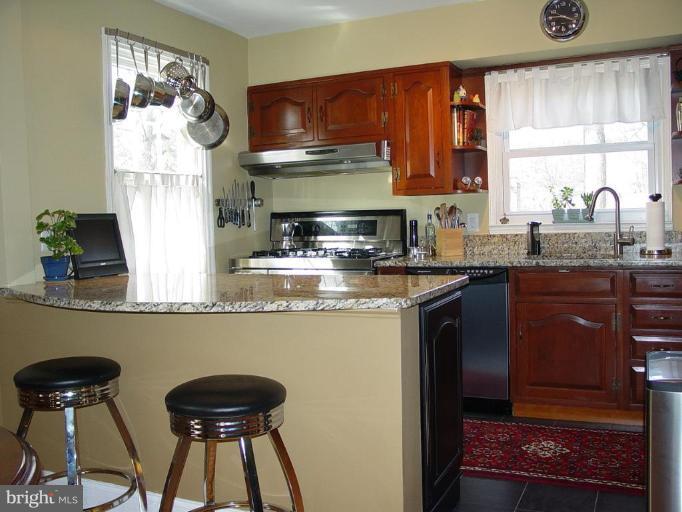 730 Overbrook Road Baltimore, MD 21212 - Photo 10 of 29 a kitchen with stainless steel appliances granite countertop a table chairs in it and wooden floors