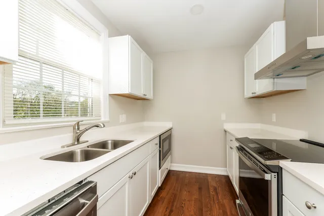 a kitchen that has a sink and wooden floor