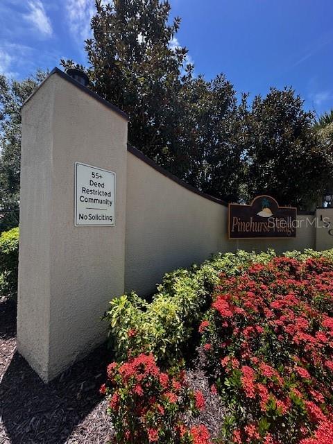 1701 Pinehurst Road, Unit 13C Dunedin, FL 34698 - Photo 2 of 28 a sign that is in front of flowers