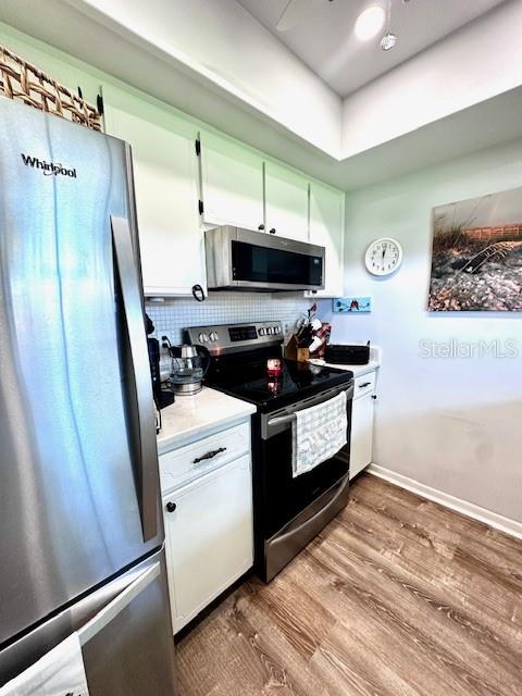 1701 Pinehurst Road, Unit 13C Dunedin, FL 34698 - Photo 8 of 28 a kitchen with stainless steel appliances a refrigerator a stove and white cabinets