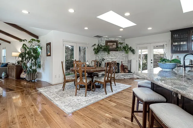 a kitchen with a dining table chairs and sink