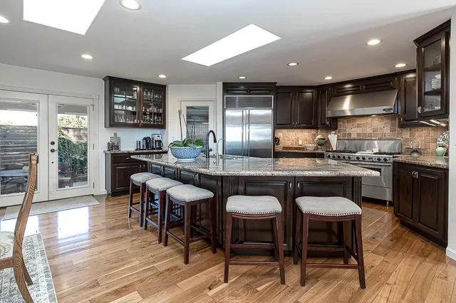 a kitchen with stainless steel appliances granite countertop a sink and a refrigerator