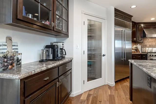 a kitchen with stainless steel appliances granite countertop a stove a sink and a refrigerator