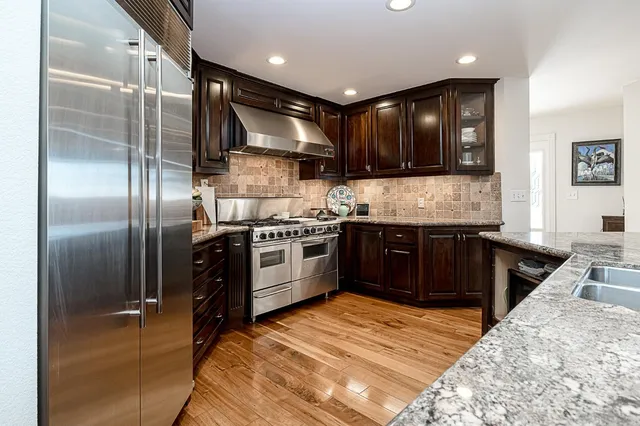 a kitchen with granite countertop a stove and a sink