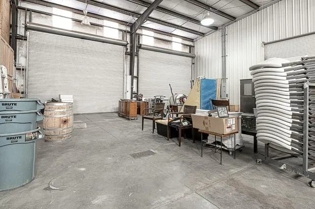 a view of a backyard with plants and barbeque grill