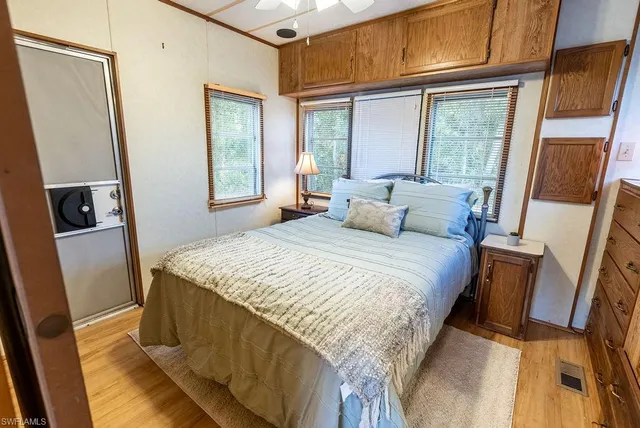 a bedroom with a bed and wooden floor