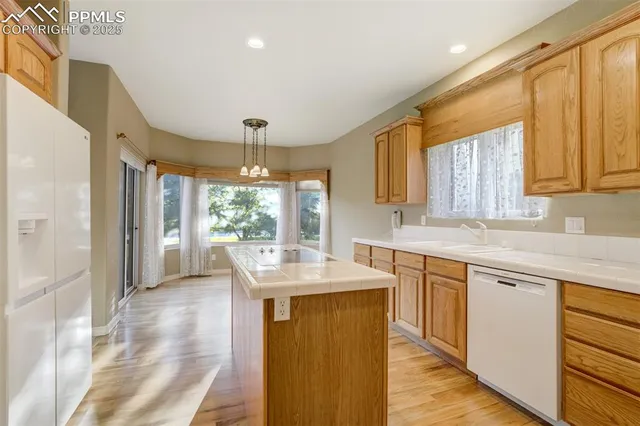 a kitchen with granite countertop a sink cabinets and wooden floor