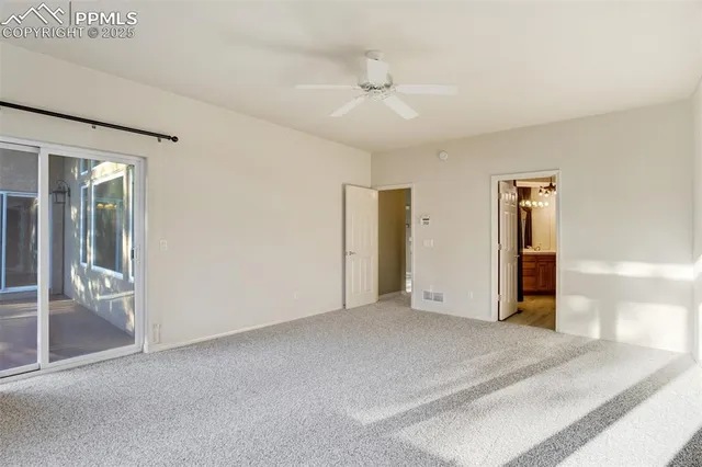 an empty room with closet and a ceiling fan