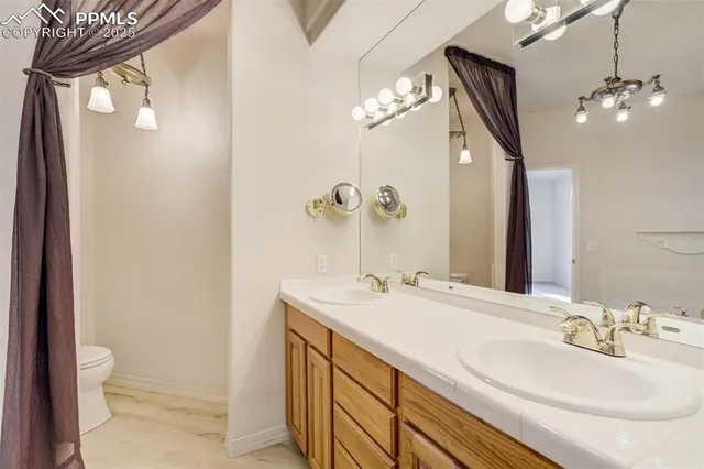 a bathroom with a sink a toilet and a mirror