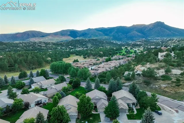 an aerial view of green landscape with trees houses and mountain view