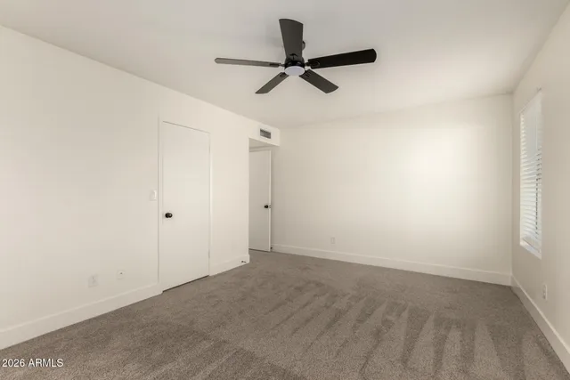 a view of a livingroom with a ceiling fan and window