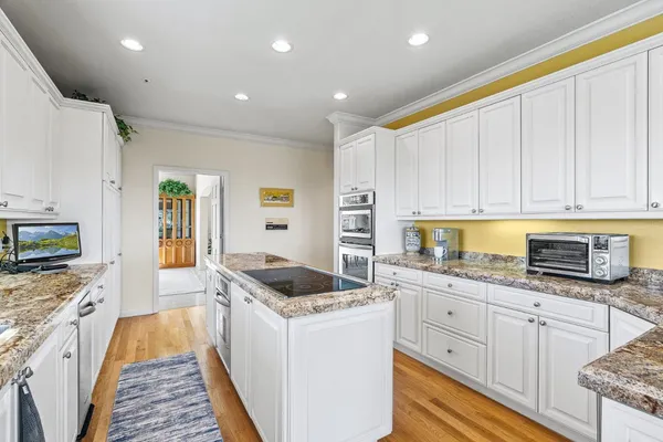 a kitchen with granite countertop a sink stove and cabinets