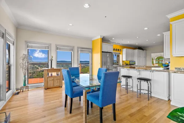 a dining room with stainless steel appliances a table and chairs