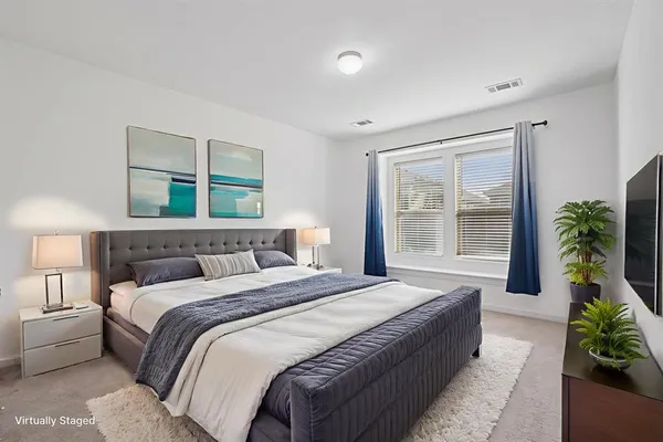 a bedroom with a large bed and a potted plant